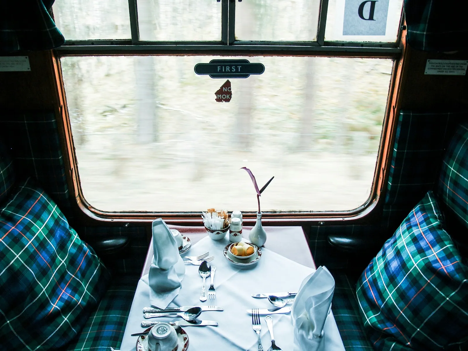 A first-class dining table set beside the window of a Scottish train